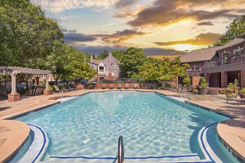 a swimming pool with a sunset in the background